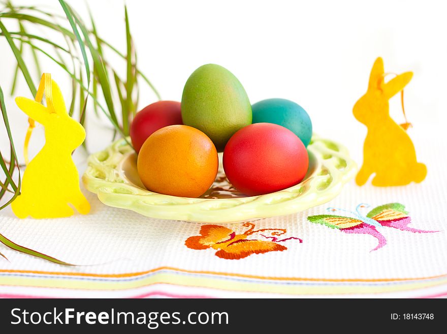 Easter eggs on a plate with rabbit decoration. Easter eggs on a plate with rabbit decoration