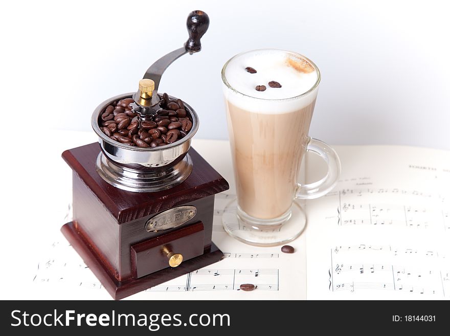 Coffee cup with coffee grader on sheet music. Coffee cup with coffee grader on sheet music