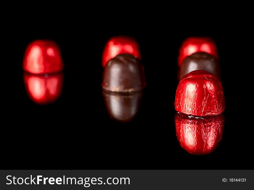 Set of sweets on redlection surface. Black background. Studio shot. Set of sweets on redlection surface. Black background. Studio shot.