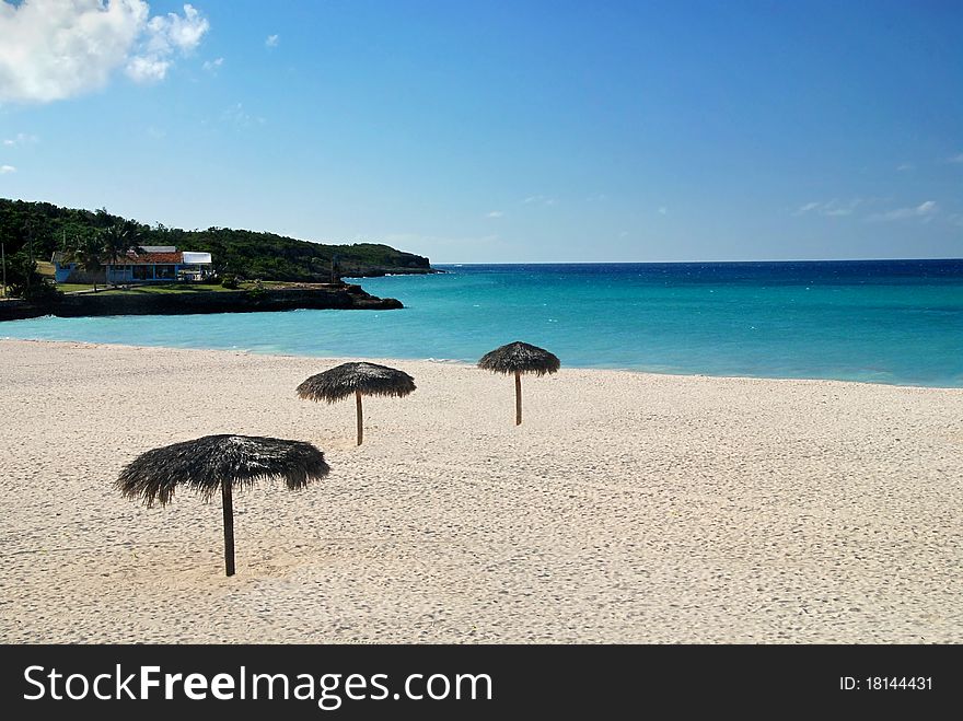 Beautiful white Cuban beach with parasols and turquoise sea. Beautiful white Cuban beach with parasols and turquoise sea