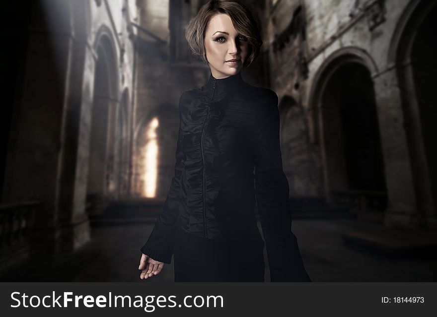 Beautiful young woman posing in a castle interior