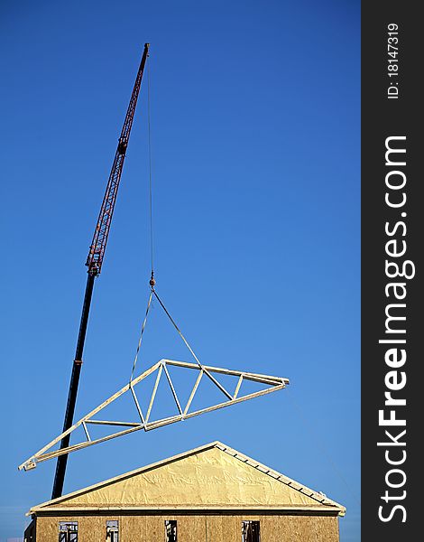 Crane lifting a roof onto a townhome. Crane lifting a roof onto a townhome