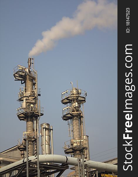 This is a modern industrial plant showing some chimneys emitting steam. This is a modern industrial plant showing some chimneys emitting steam.