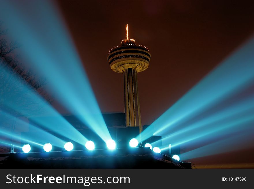 Night view of the Skylon tower at Niagara Falls beween the spotlights for the falls. Night view of the Skylon tower at Niagara Falls beween the spotlights for the falls