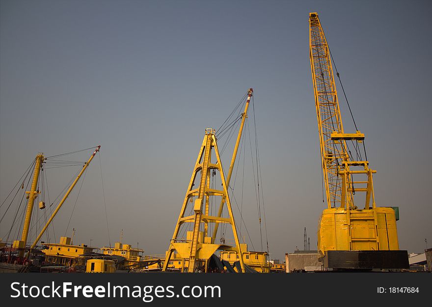 Cargo ships with their own cranes are docked at the shipyards in Hong Kong. Cargo ships with their own cranes are docked at the shipyards in Hong Kong.