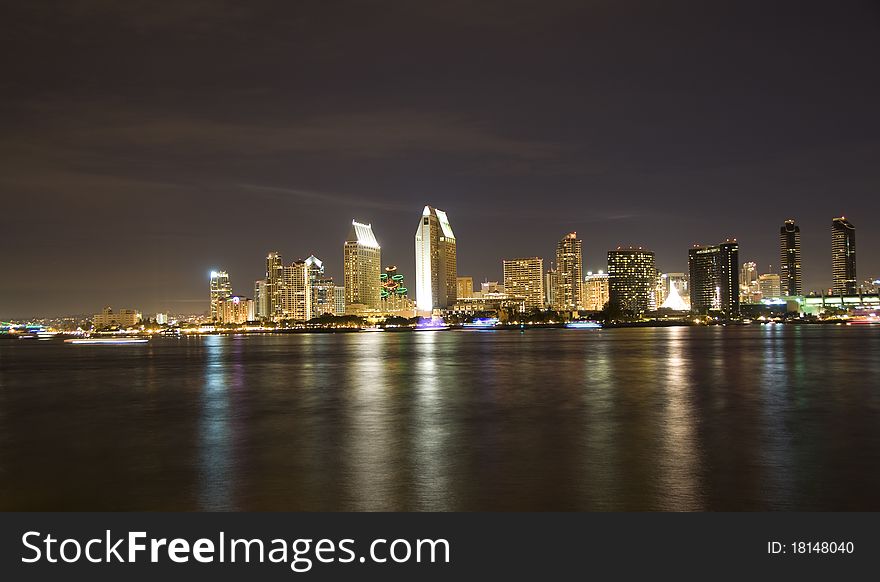 Downtown San Diego at night. Boats on the bay decorated with lights show motion blur. Downtown San Diego at night. Boats on the bay decorated with lights show motion blur.