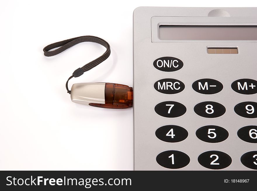 A large calculator with USB flash drive on white background