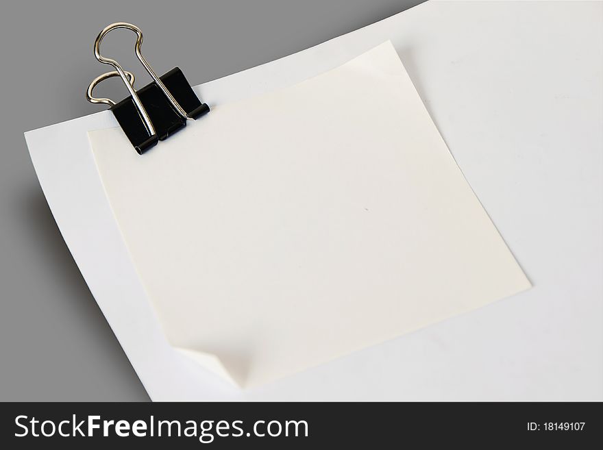 Sheet of white paper note with black clip