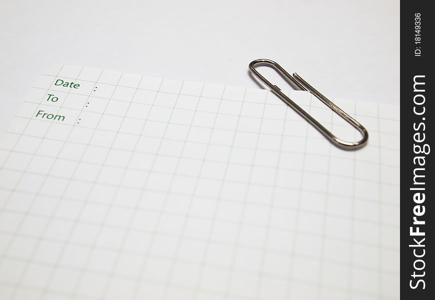 White paper note with table and metal clip