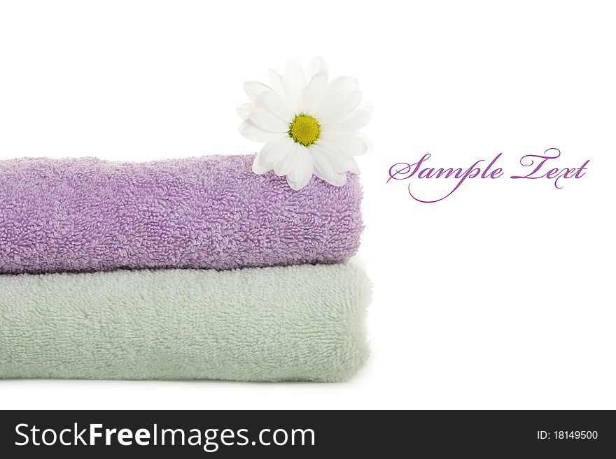 Stacked colorful towels with white flower. Isolated over white