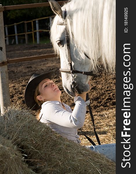 Portrait of young woman with her white horse on the farm yard. Portrait of young woman with her white horse on the farm yard