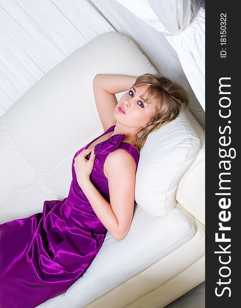 Sexy blond girl lying on a white sofa. Sexy blond girl lying on a white sofa