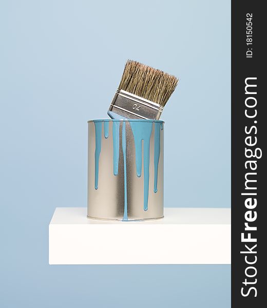 Paintcan and brush on blue background