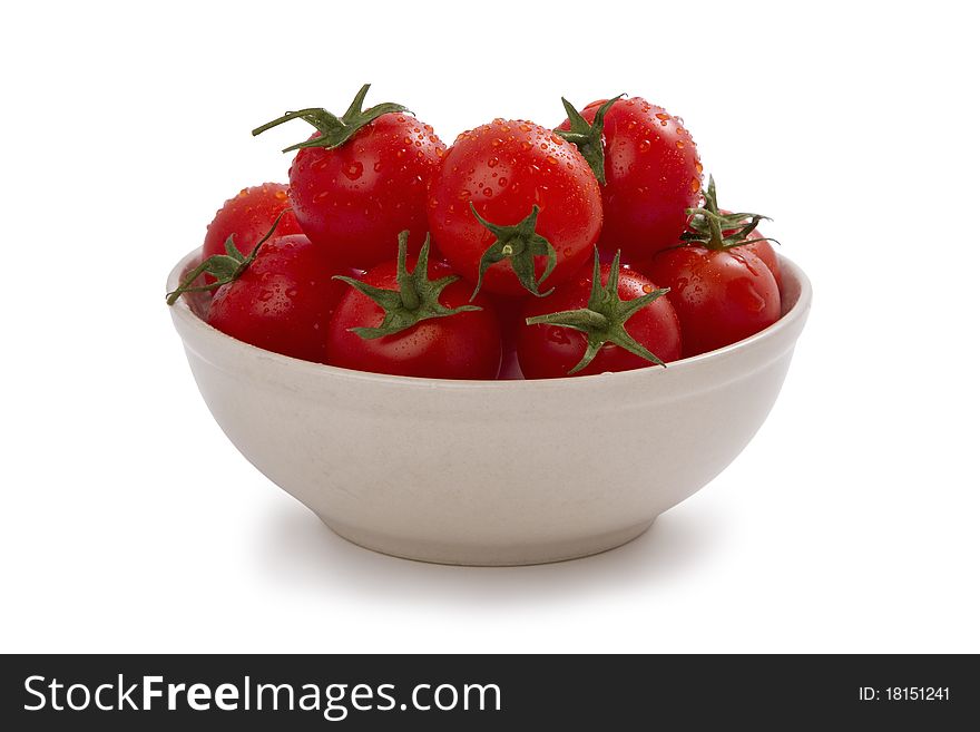 Ripe cherry tomatoes on a plate, isolated on white.
