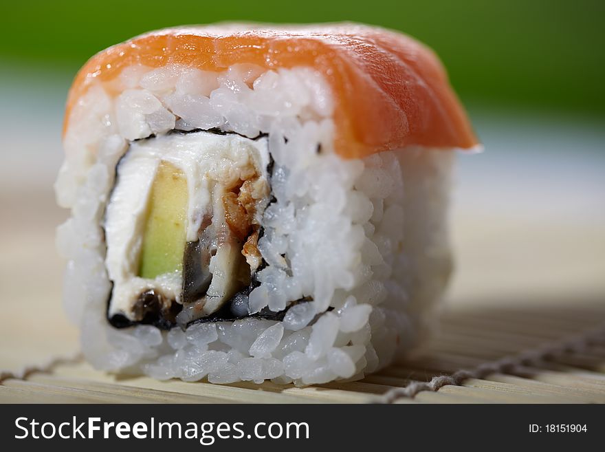 Close-up shoot of delicious maki sushi with smoked salmon, avocado and cheese. Traditional Asian food. Close-up shoot of delicious maki sushi with smoked salmon, avocado and cheese. Traditional Asian food.