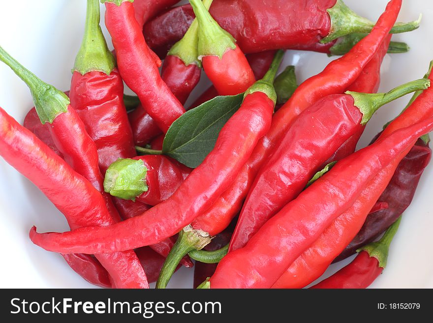 Close-up of red chili peppers piled in a white bowl. Close-up of red chili peppers piled in a white bowl