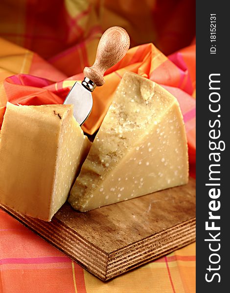 Parmesan cheese on chopping board with knife