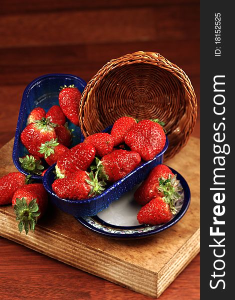 Small baskets with strawberries on chopping board