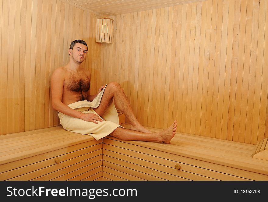 Young handsome man in a russian wooden sauna