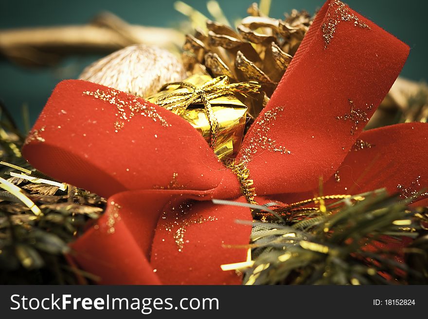 Close up of big red bow with golden christmas decoration on green satin background. Close up of big red bow with golden christmas decoration on green satin background