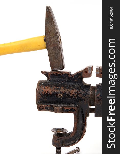 Rusty old bench vise and a hammer on a white background