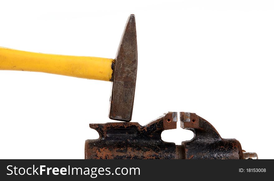 Rusty old bench vise and a hammer on a white background