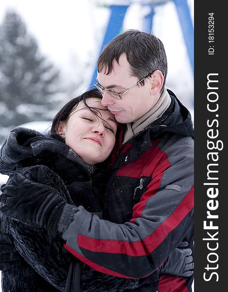 Happy couple hugging in winter time