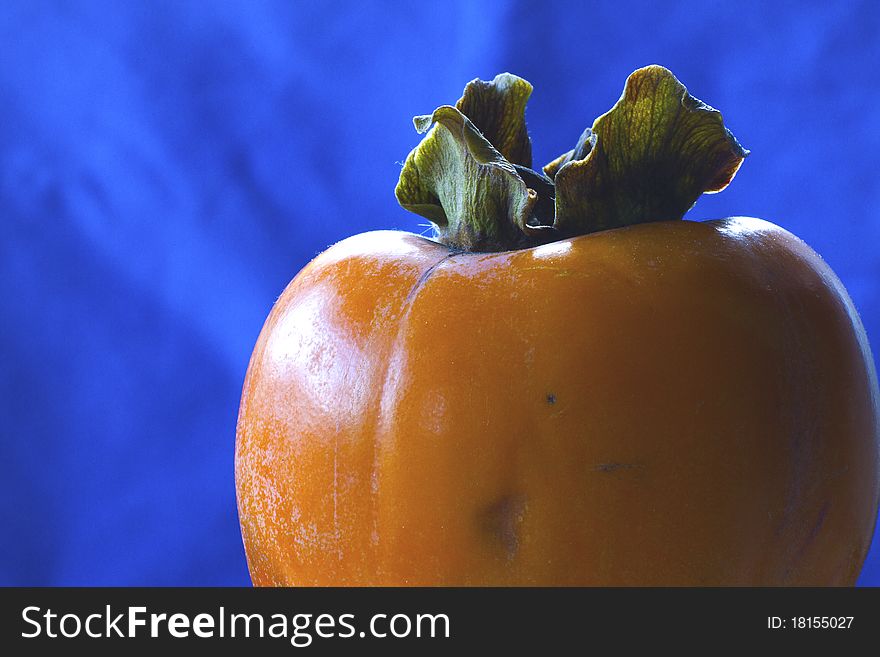 Persimmons isolated on blue background