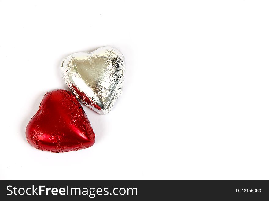 Red and silver chocolate hearts on a white background