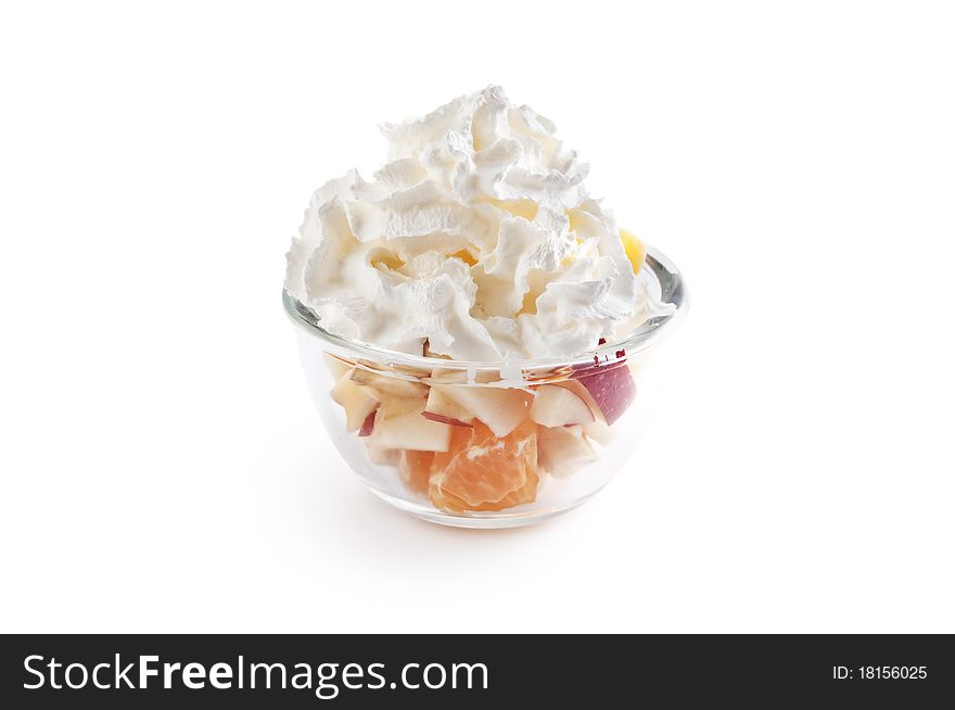 Fruit salad with whipped cream in the glass bowl isolated on white. Fruit salad with whipped cream in the glass bowl isolated on white