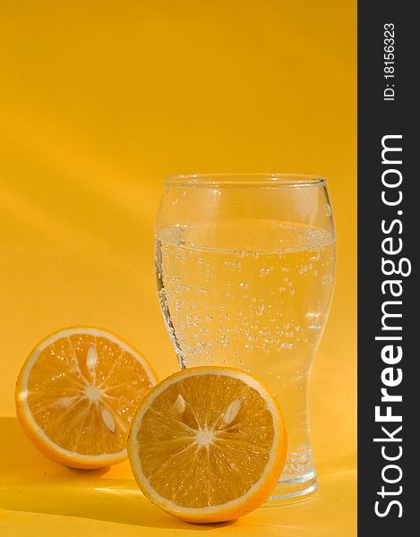 A glass of soda and two chopped oranges