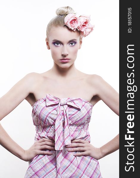 Portrait of young beautiful woman with roses in hair, on white background