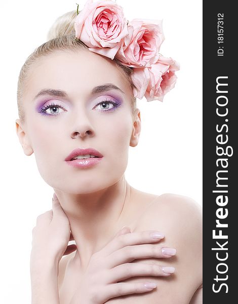 Portrait of young beautiful woman with roses in hair, on white background