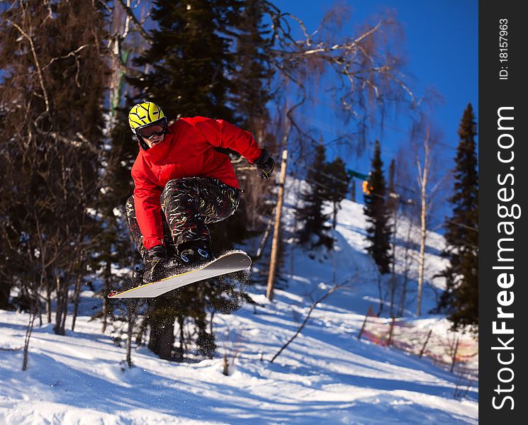 Snowboarder jumping through air with deep blue sky in background