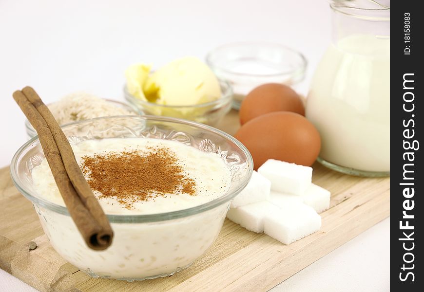 Creamy rice pudding on  bowl with cinnamon and all the ingredients. Creamy rice pudding on  bowl with cinnamon and all the ingredients