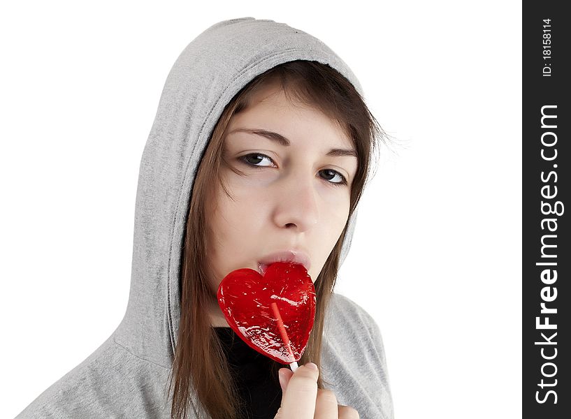 Candy red heart in the girl's lips on a white background