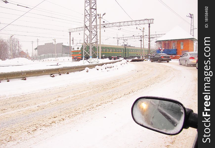 The image of cars stand at a railroad crossing