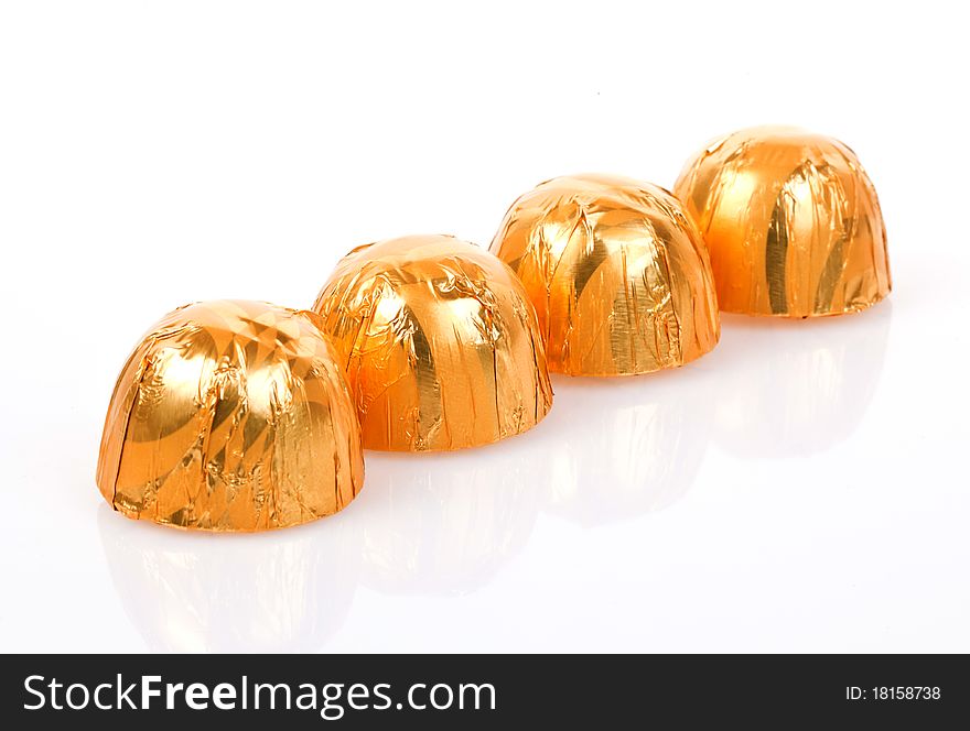 Delicious chocolate pralines wrapped in gold paper. Delicious chocolate pralines wrapped in gold paper