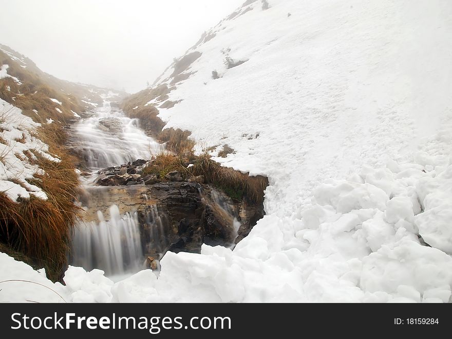 Beautiful waterfall in the mountains during the winter