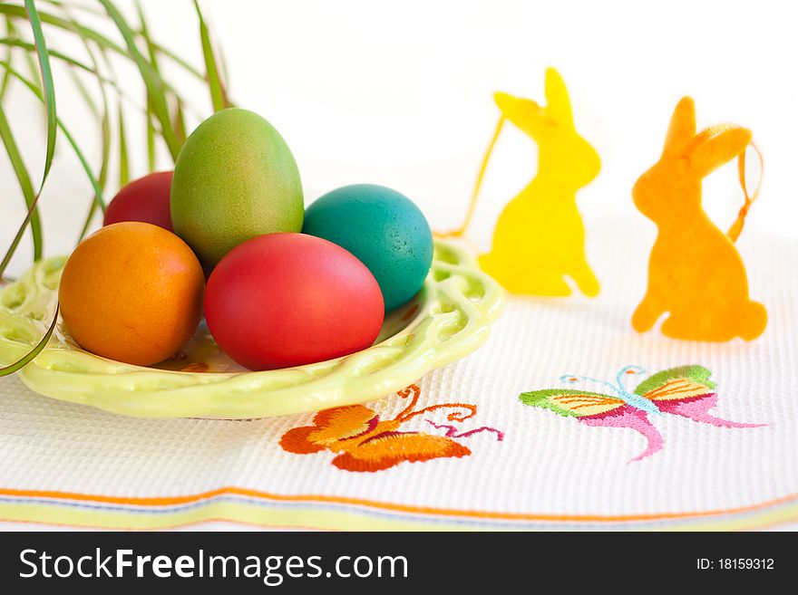 Easter eggs on a plate with rabbit decoration. Easter eggs on a plate with rabbit decoration