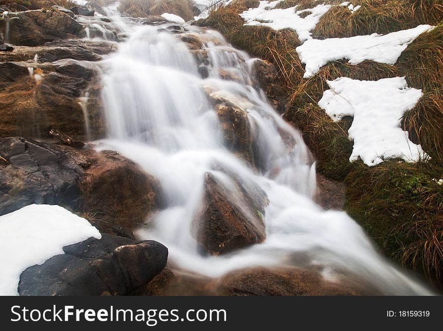 Beautiful waterfall in the mountains during the winter