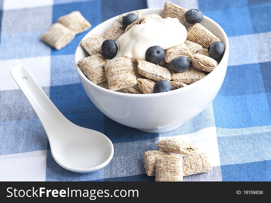 Wholegrain shredded wheat with creme fraiche and blueberries in a bowl