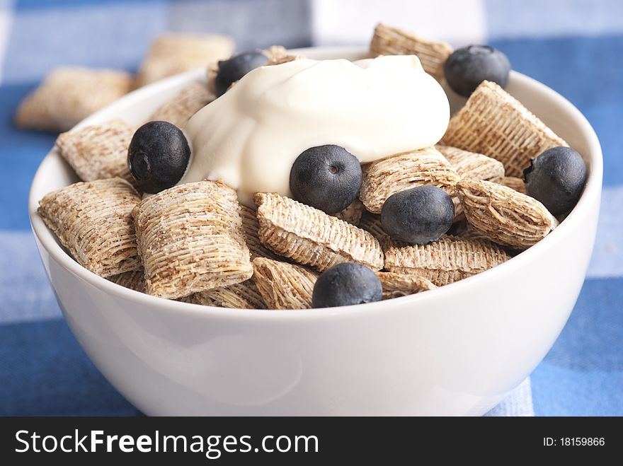 Wholegrain shredded wheat with creme fraiche and blueberries in a bowl