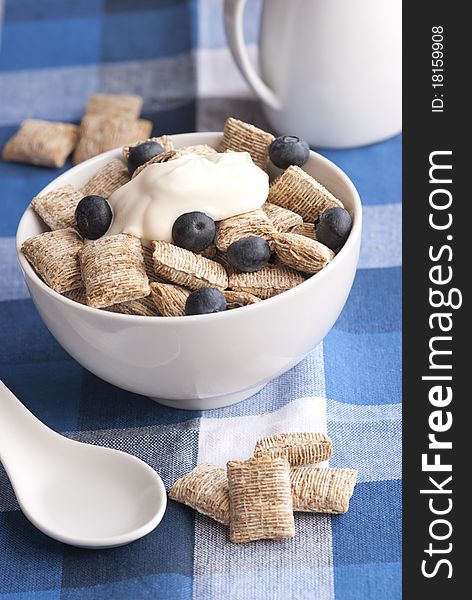 Wholegrain shredded wheat with creme fraiche and blueberries in a bowl