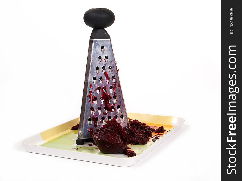 Metal kitchen grater with beets on a white background