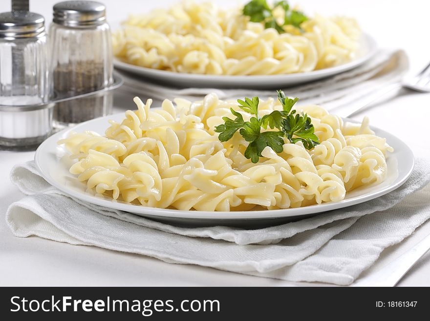 Two plates of pasta with parsley