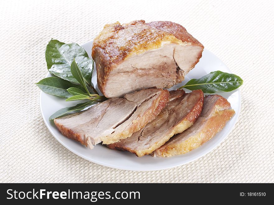 Roasted pork with bay leaf on plate