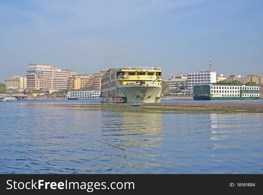 A large river boat on the Nile in Egypt with hotels in the background