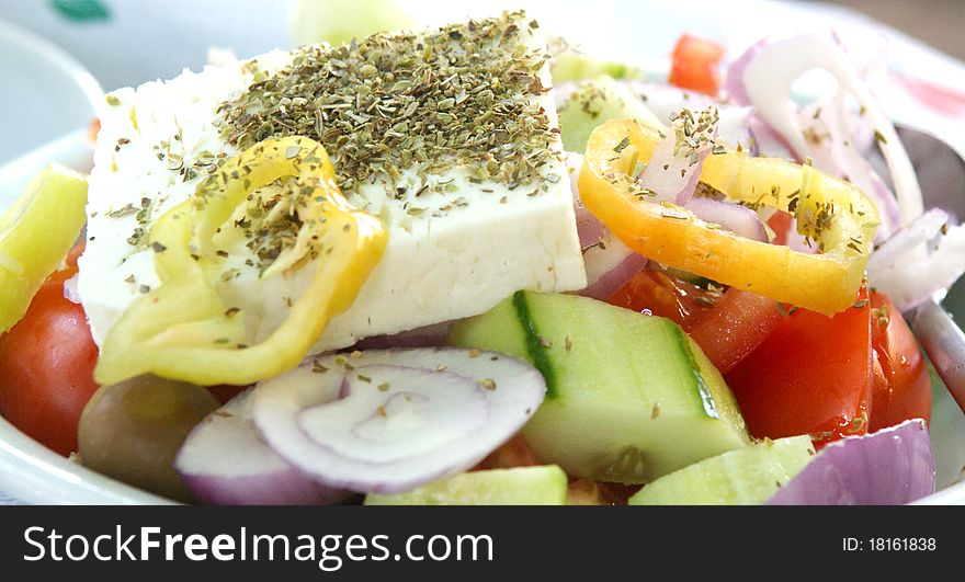 A plate of Greek Salad with onions, cuccumber