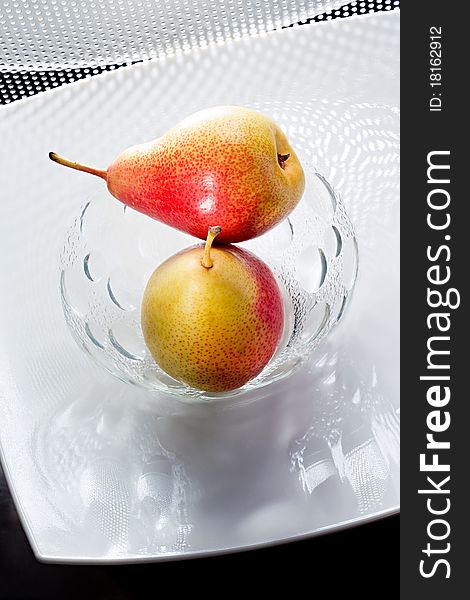 Two appetizing pears on the white glass plate. Two appetizing pears on the white glass plate